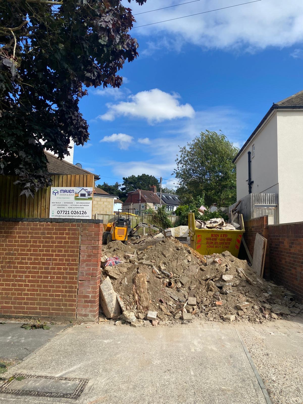 Rear extension with rendered walls, slate-clad upper storey, skylights, and large rear glazing — typical scope where depth and impact matter for prior approval